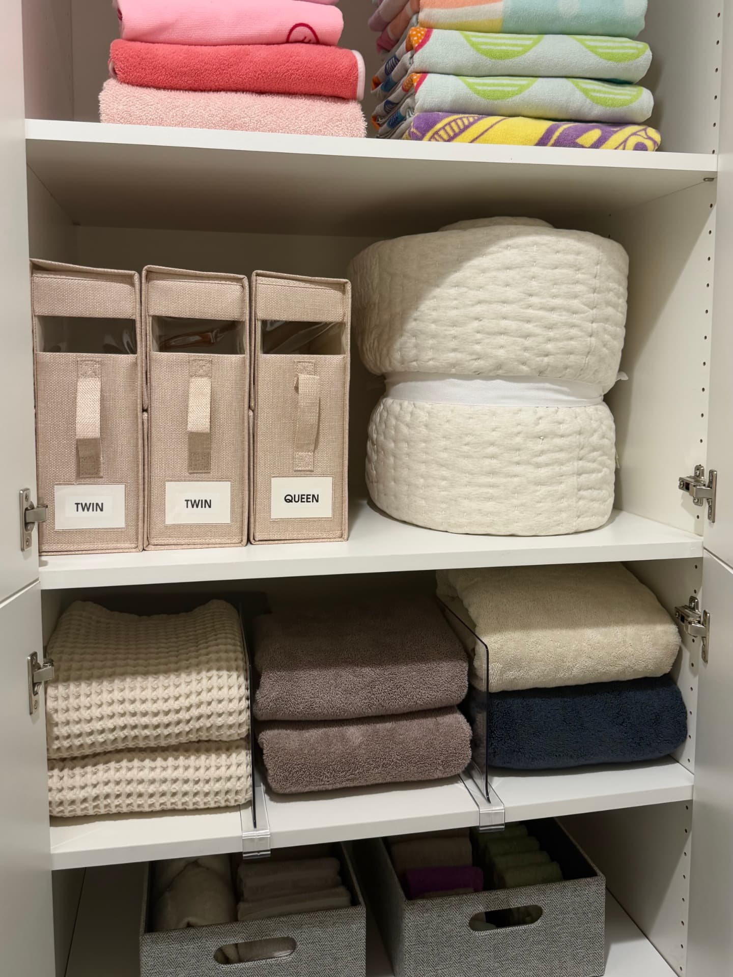 Full linen closet with sheet bins, comforters, bath towels, and washcloth baskets