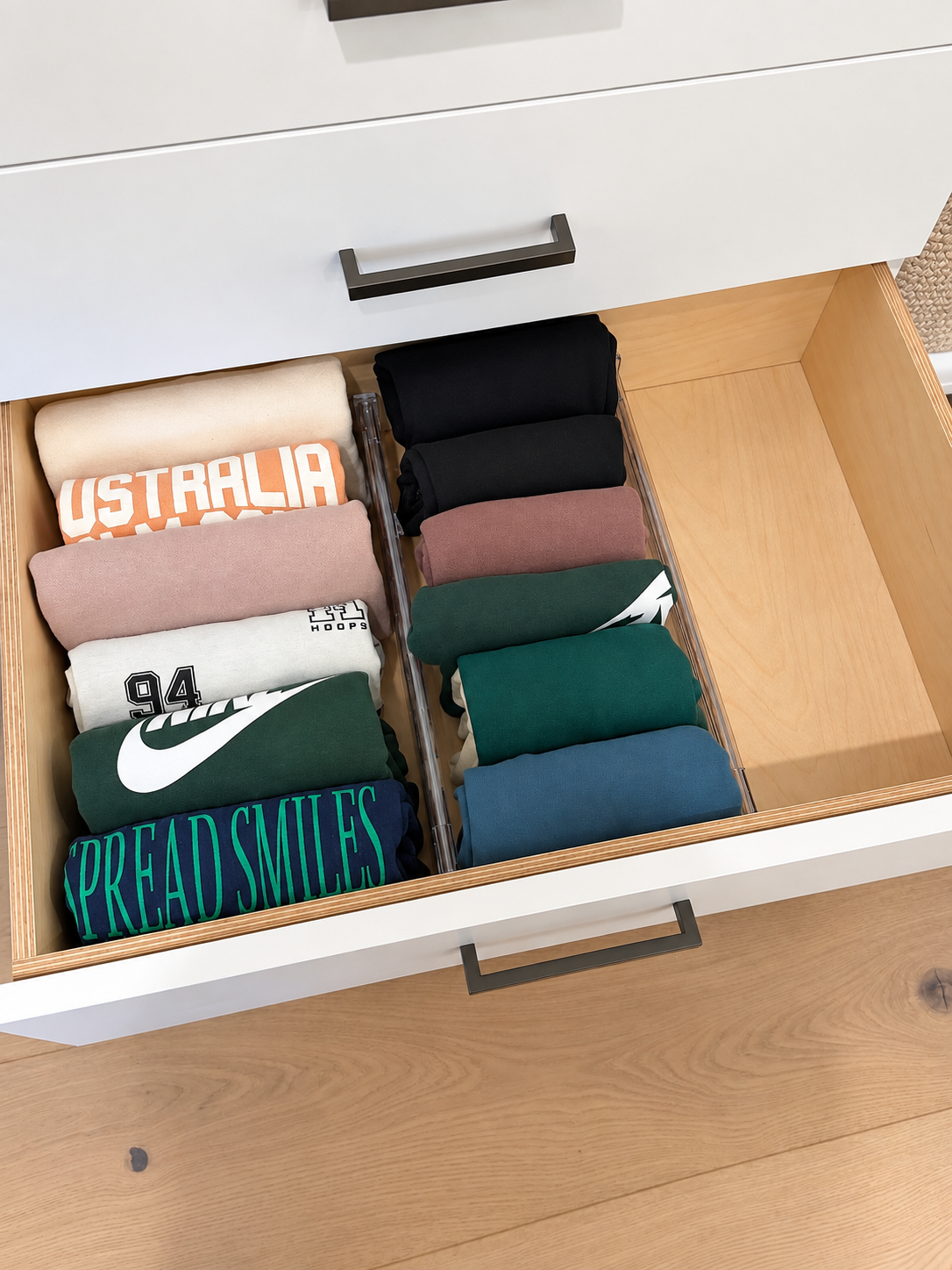 Open closet drawer with neatly file-folded children’s sweatshirts