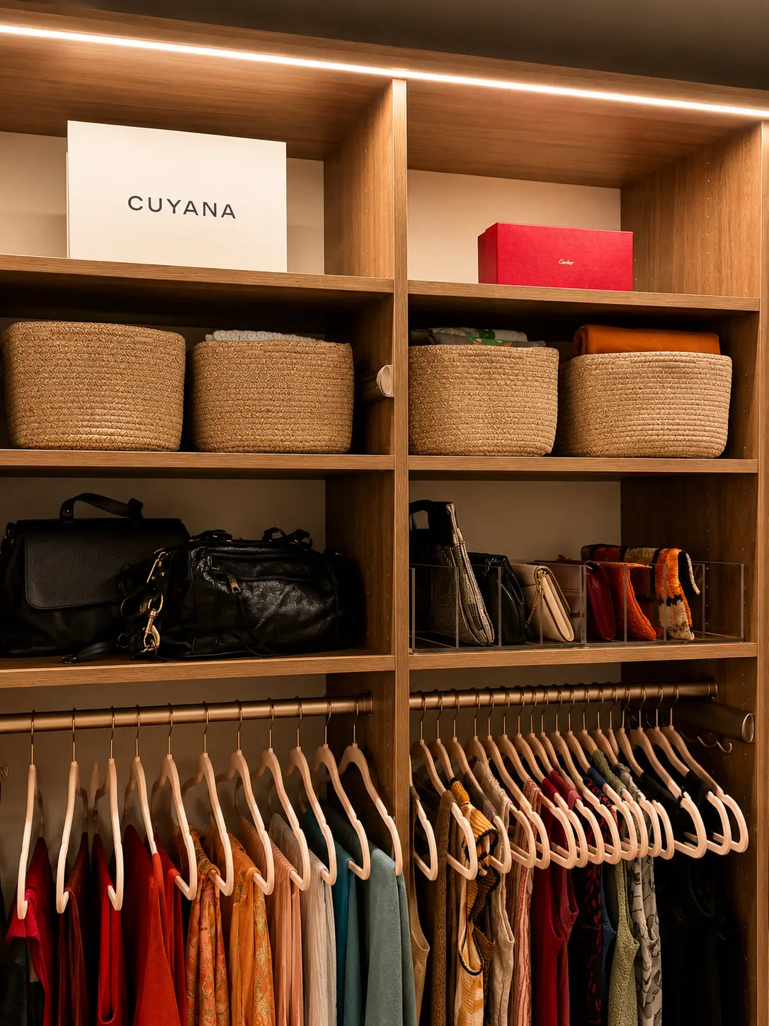 Master closet shelves with woven baskets of folded knits, designer boxes, handbags on a shelf, and clutches displayed in clear organizers
