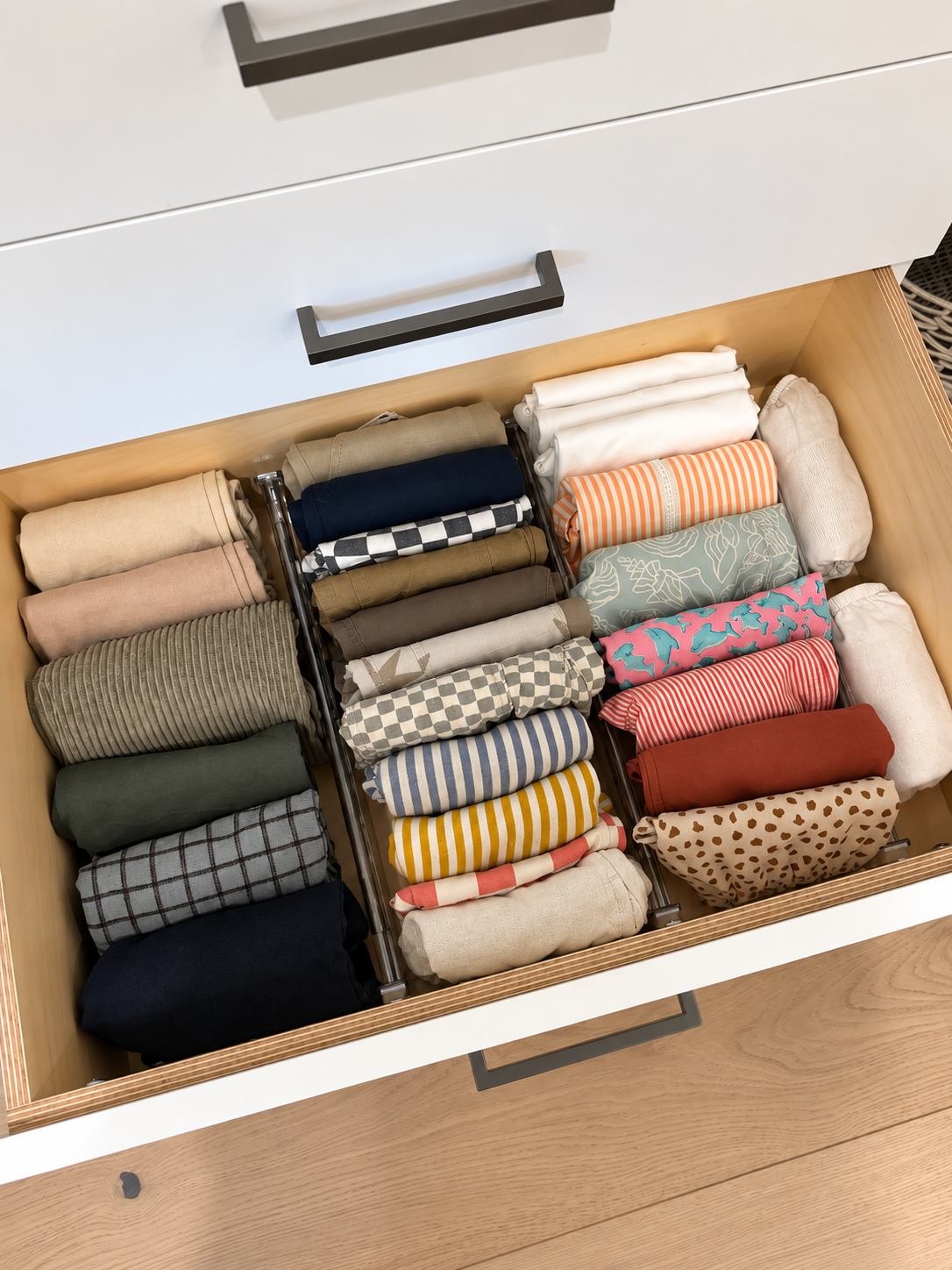 Open closet drawer with neatly file-folded children’s patterned clothes